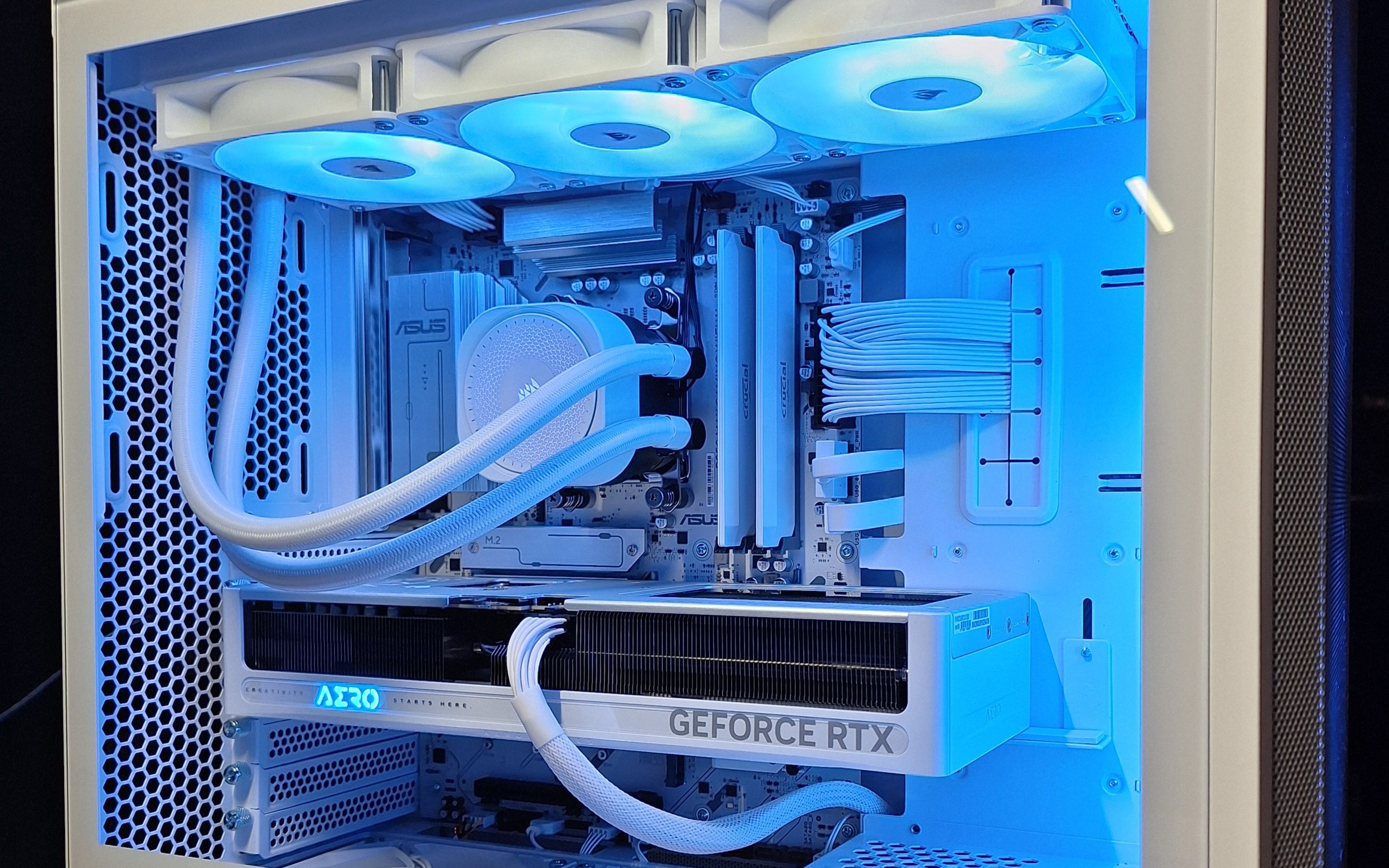 Close-up of the blue-lit white liquid cooler, memory, graphics card, and routed power cables